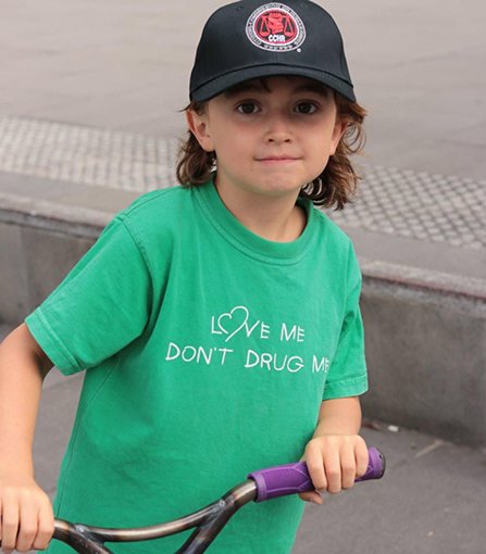 Love me, don’t drug me reads the T-shirt of the child of one of the protesters.