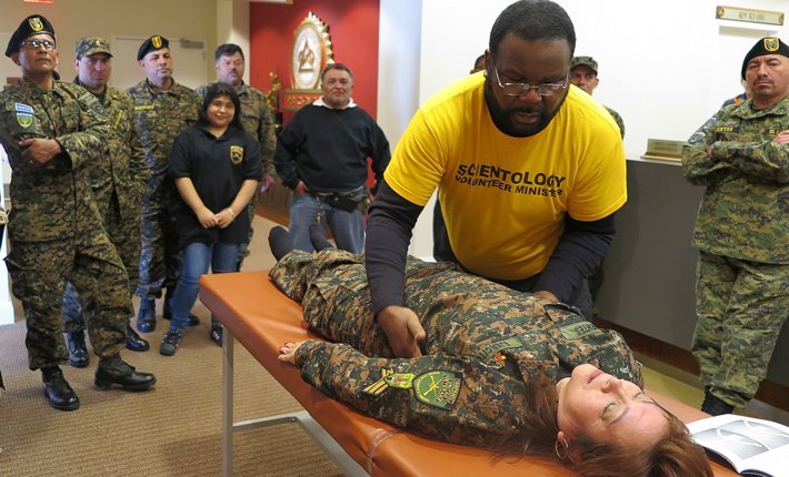 The Director of Public Affairs demonstrated to the veterans how to perform a Scientology assist by providing one to one of the members of the group.