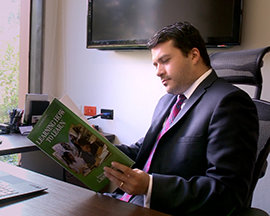 Scientologist Alejandro at desk with Study Tech book