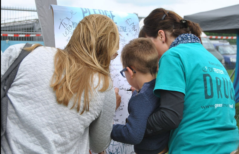 Mother helps her son sign the drug-free pledge.