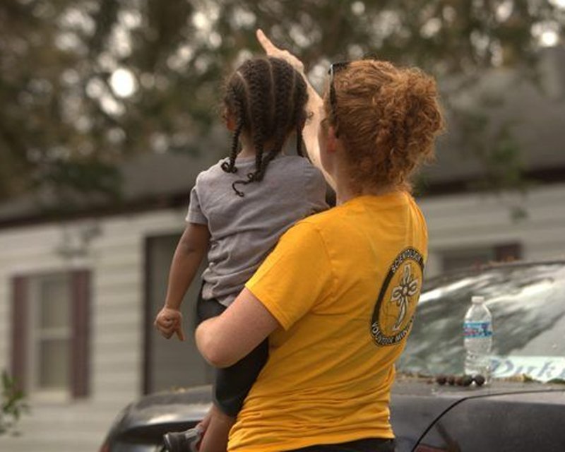 A Volunteer Ministers points out things in the environment to a little girl to help orient her with a Scientology Locational Assist—one of the techniques that can help a person recover from the trauma connected with sudden disasters.